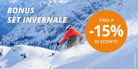 Sciatore in giacca rossa che scende lungo un pendio montuoso innevato, con pini e montagne innevate sullo sfondo. Un cerchio arancione pubblicizza "FINO A -20% DI SCONTO". Il testo recita "BONUS SET INVERNALE".