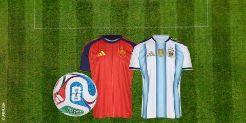 Due maglie da calcio, una rossa (Spagna) e una bianca a strisce blu (Argentina), sullo sfondo di un campo da calcio verde con un pallone della Coppa del Mondo FIFA.